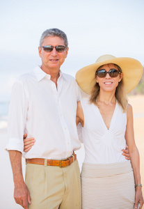 中间的老年的夫妇享受走在沙滩上
