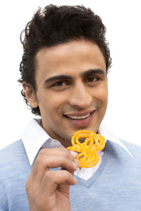 微笑的男人吃 jalebi