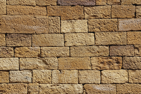 用于背景或质地的金砂砖墙。黄砂石墙特写