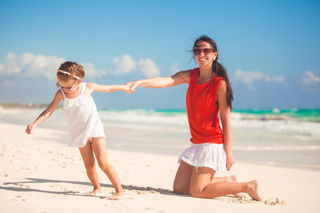 母亲带着她可爱的女儿享受假期和在墨西哥的海滩玩
