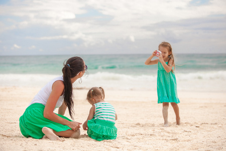 小女孩的照片她的妈妈和妹妹在沙滩上