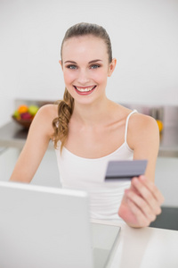 幸福的年轻女人，用她的笔记本电脑在线购物