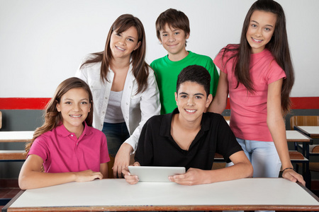 在桌子上使用平板电脑的青少年学生的肖像