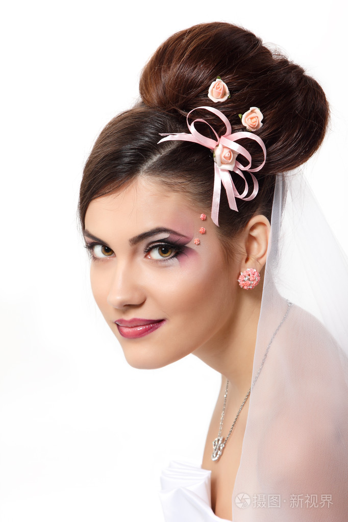 与美丽的妆容和发型在面纱下的美丽年轻的新娘