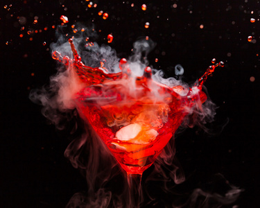 红色鸡尾酒溅水和冰的蒸气