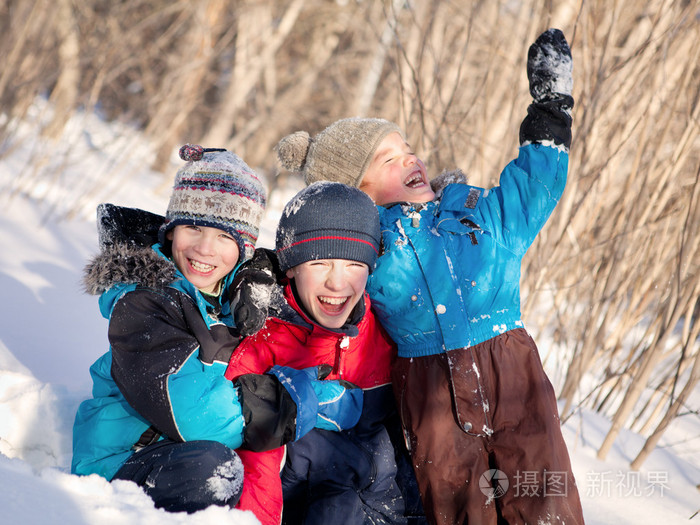 冬装笑在雪堆里玩耍的孩子