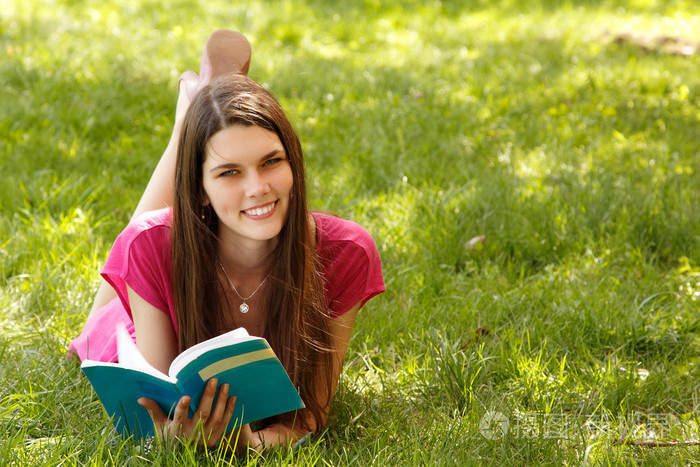 在春天的花园里快乐的学生女孩读书
