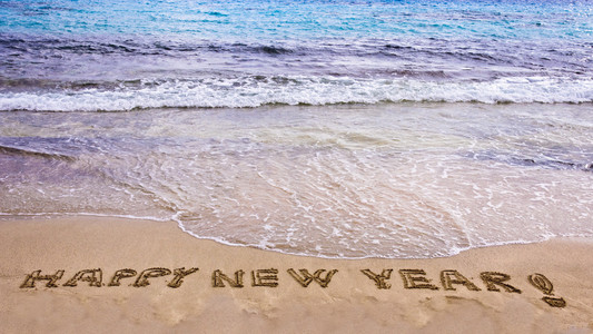 新年快乐和感叹号写在沙滩上