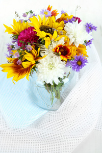 野花在明亮的背景上有玻璃花瓶中的花束