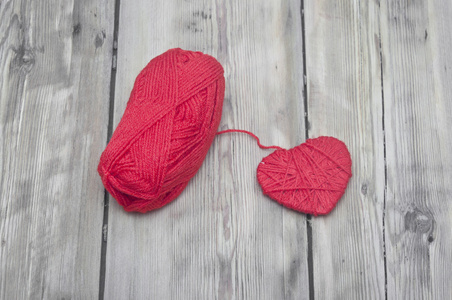 针织的心和红色的纱木背景