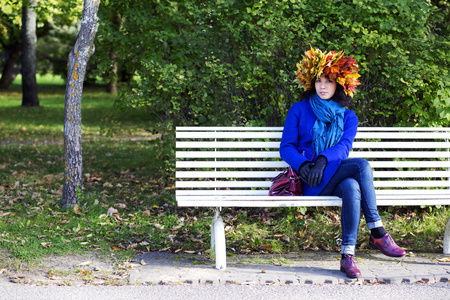 女人的头靠在长椅上的叶子