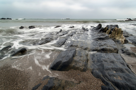 锯齿状和坚固岩石与海岸线上的风景海景
