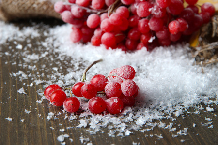 琼花和雪上麻布餐巾，木制背景上的红色浆果
