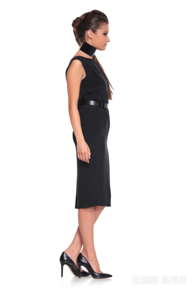 穿着黑色连衣裙的年轻时尚女性的侧视图