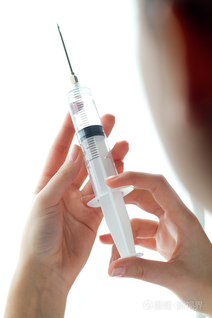 女人的手控股注射器