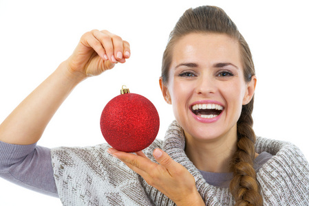 幸福的年轻女人，穿着毛衣显示圣诞球