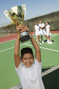 男孩抱着网球奖杯