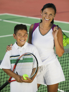 母亲和儿子在网球场上