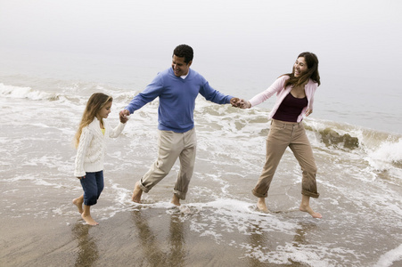 赤脚走在海滩上的家庭图片