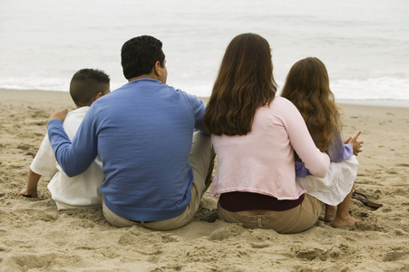 坐在沙滩上的家庭