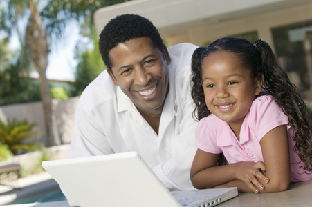父亲和女儿使用的便携式计算机