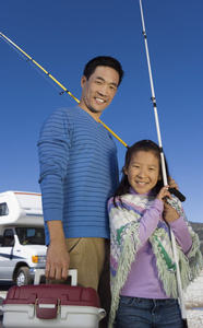 父亲和女儿抱钓鱼杆