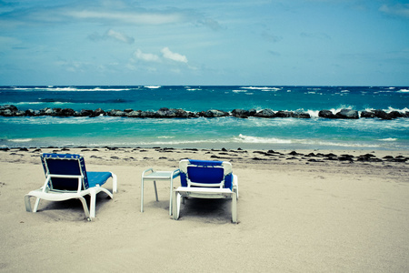平静的海滩与躺椅在蓝蓝的天空下