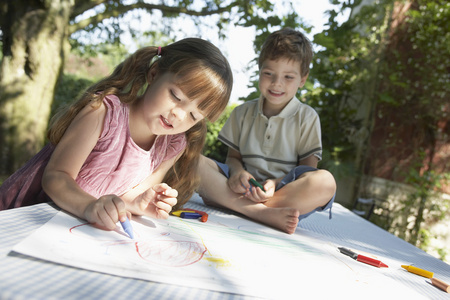 年轻的男孩和女孩在花园里画