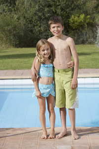 姐姐和弟弟站在游泳池旁