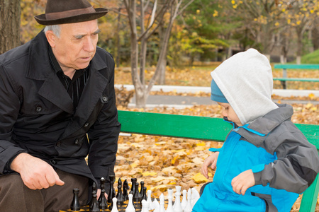 教他的孙子下棋的老人