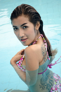 亚洲小姐穿比基尼泳装在游泳池里