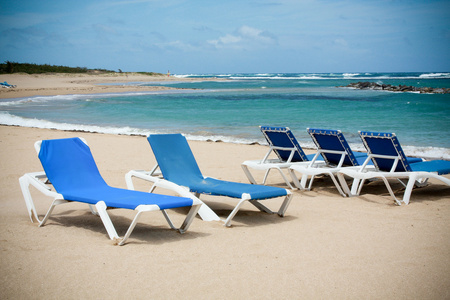 平静的海滩与躺椅在蓝蓝的天空下