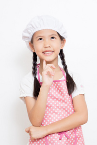 小亚洲可爱厨师戴着粉红色的围裙的思考行动