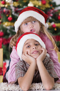快乐的小男孩笑在他的妹妹拥抱关于圣诞的肖像