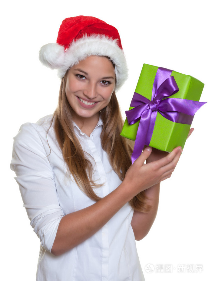 美丽的女人戴着圣诞帽子她手里拿着一份礼物