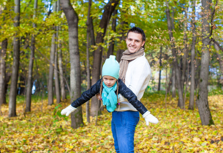 快乐爸爸和小女儿在阳光明媚的秋日，在公园里玩