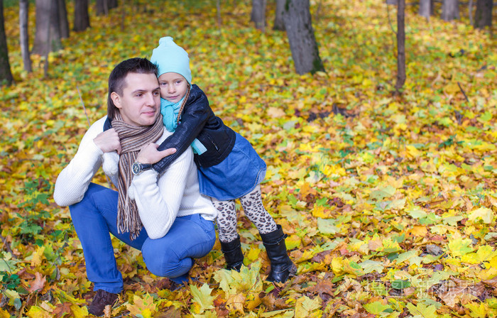 可爱的小女儿，和年轻的爸爸一起享受秋天假期在晴朗的一天