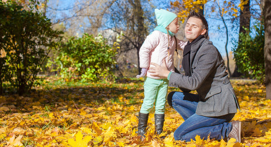 小女孩亲吻了她的父亲在片秋色的公园