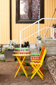 彩色的铁椅子和一张桌子的入口处的街道上