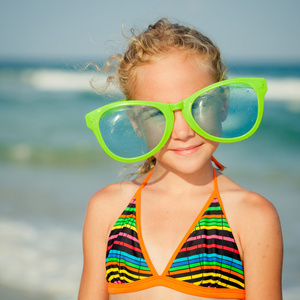 快乐的女孩，在海滩上的大墨镜