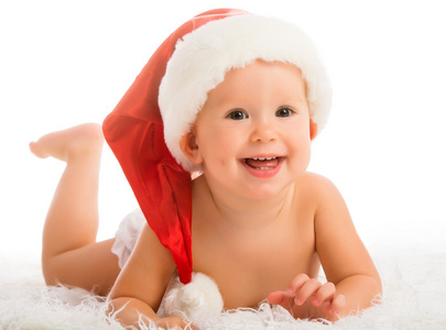 美丽有趣的婴儿在孤立在白色圣诞帽子