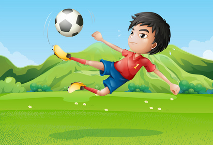 一个年轻的男孩踢足球，在字段