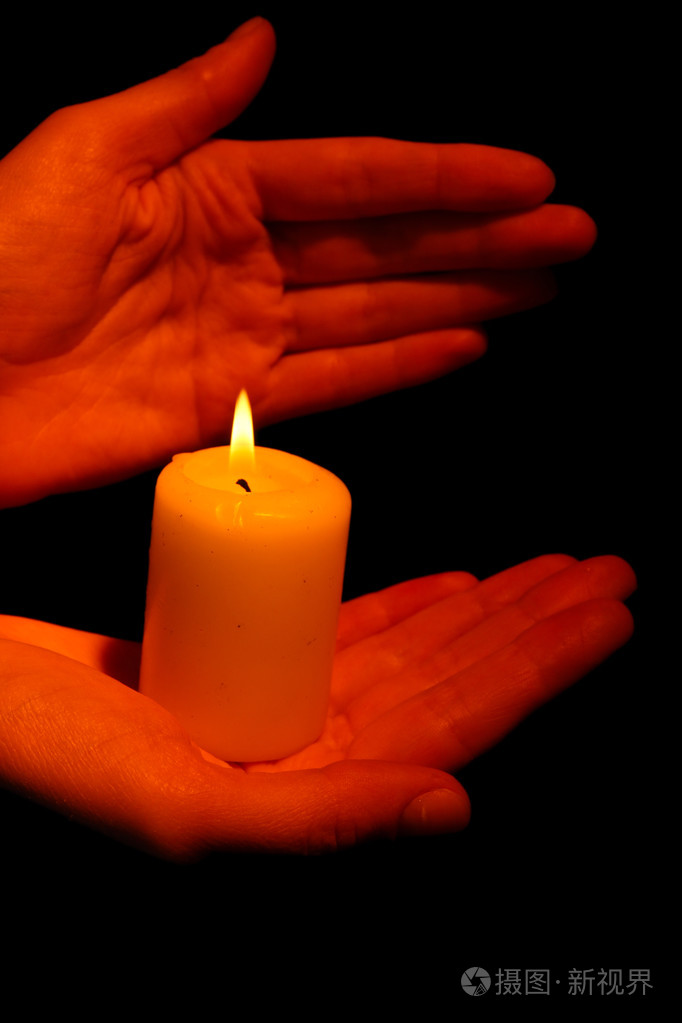 燃烧的蜡烛在手上黑色孤立