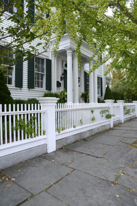 白色的栅栏，由一个典型的联邦风格的房子