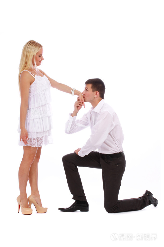 对年轻的夫妇穿着一件白色的衣服男人亲吻她的手