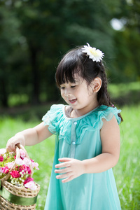 亚洲小姑娘提着篮子花