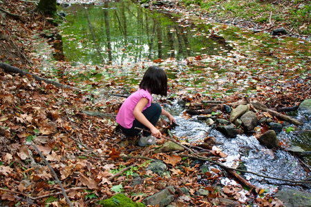 kleine Mdchen spielen mit Wasser in einem Fluss