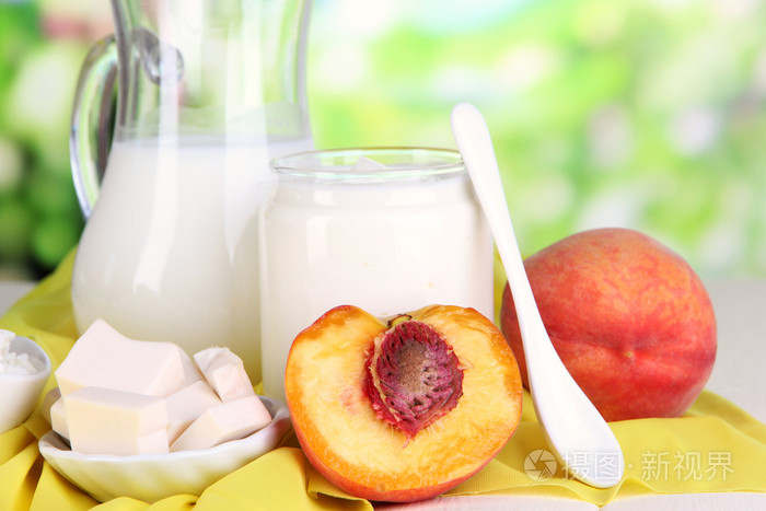 与自然背景上的木桌上的桃子新鲜奶制品