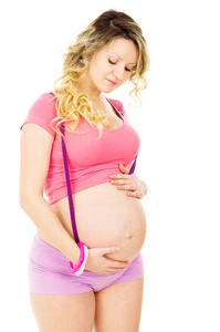 怀孕的女孩站和抱着肚子