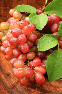 新鲜红葡萄在棕色的木头上